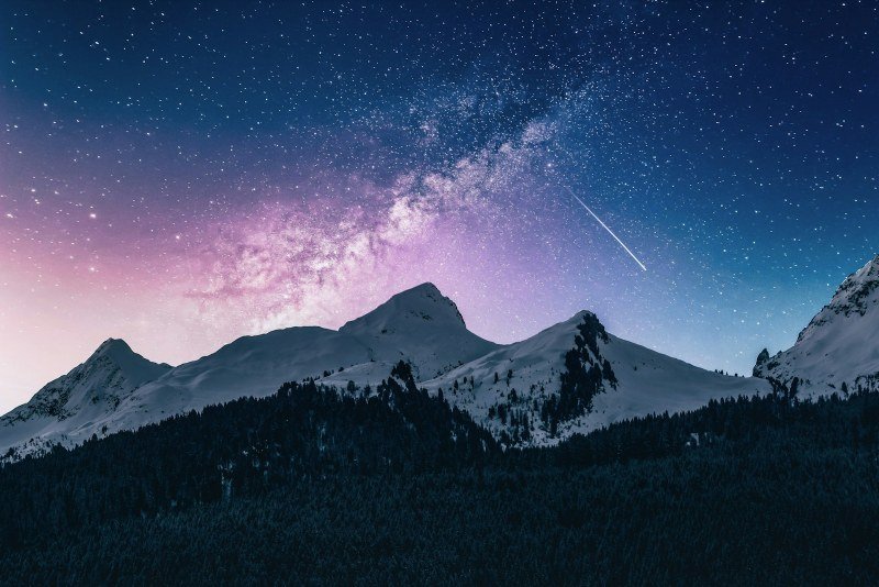 Milky Way over snow-capped mountains at night