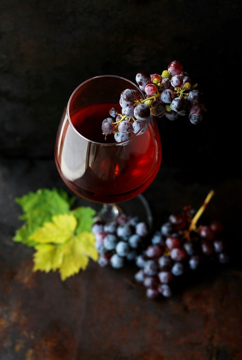 Glass of red wine with a bunch of grapes