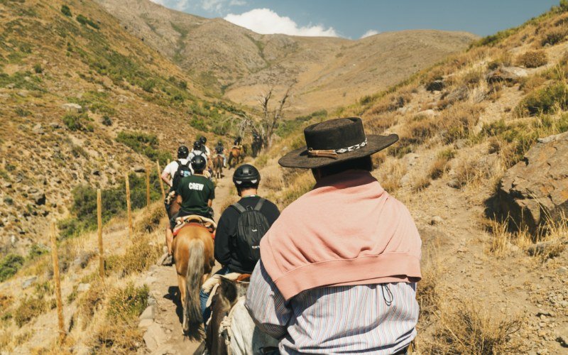 View from horseback on a canyon trail with a huaso leading ahead