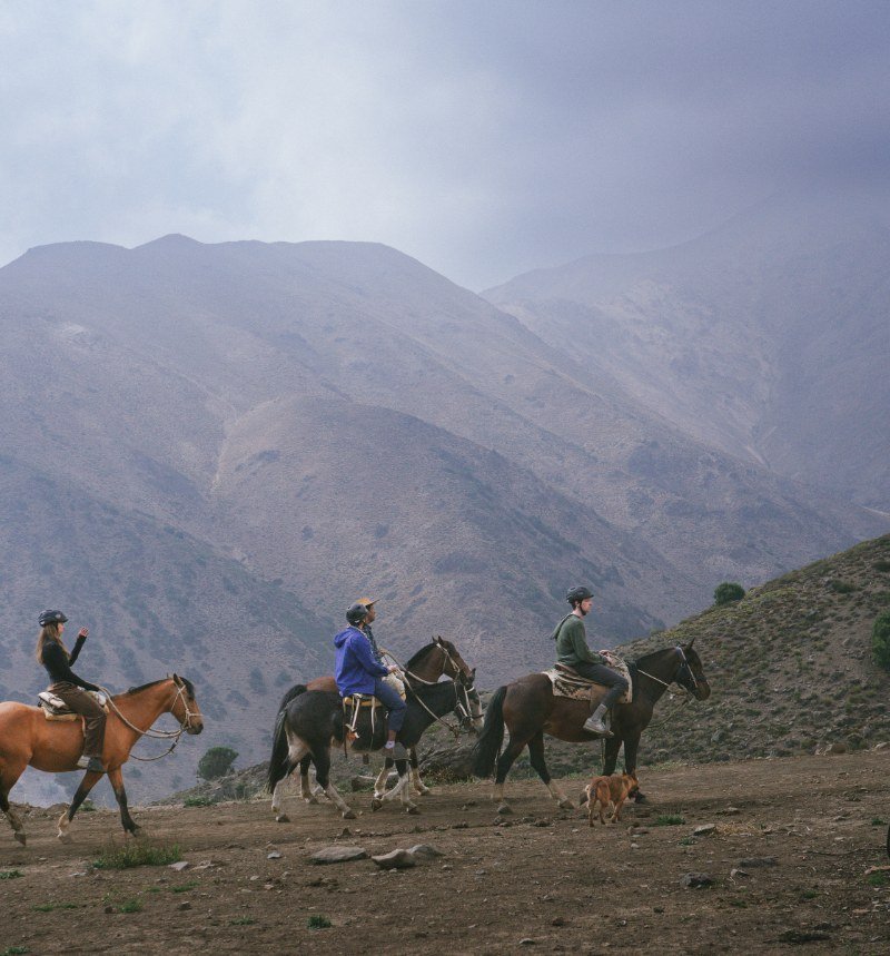 Riders on horseback crossing an Andes valley near Santiago