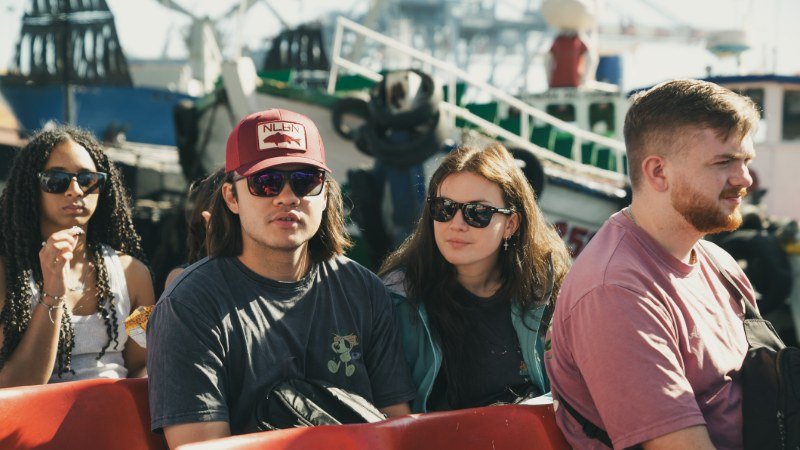 Group seated on the boat at Valparaíso port with fishing vessels in the background
