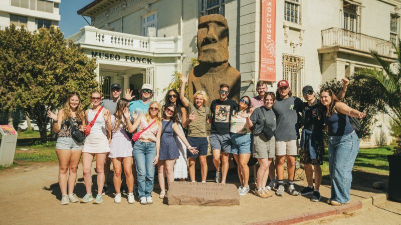 Full group photo in front of the original Easter Island Moai at Museo Fonck, Viña del Mar
