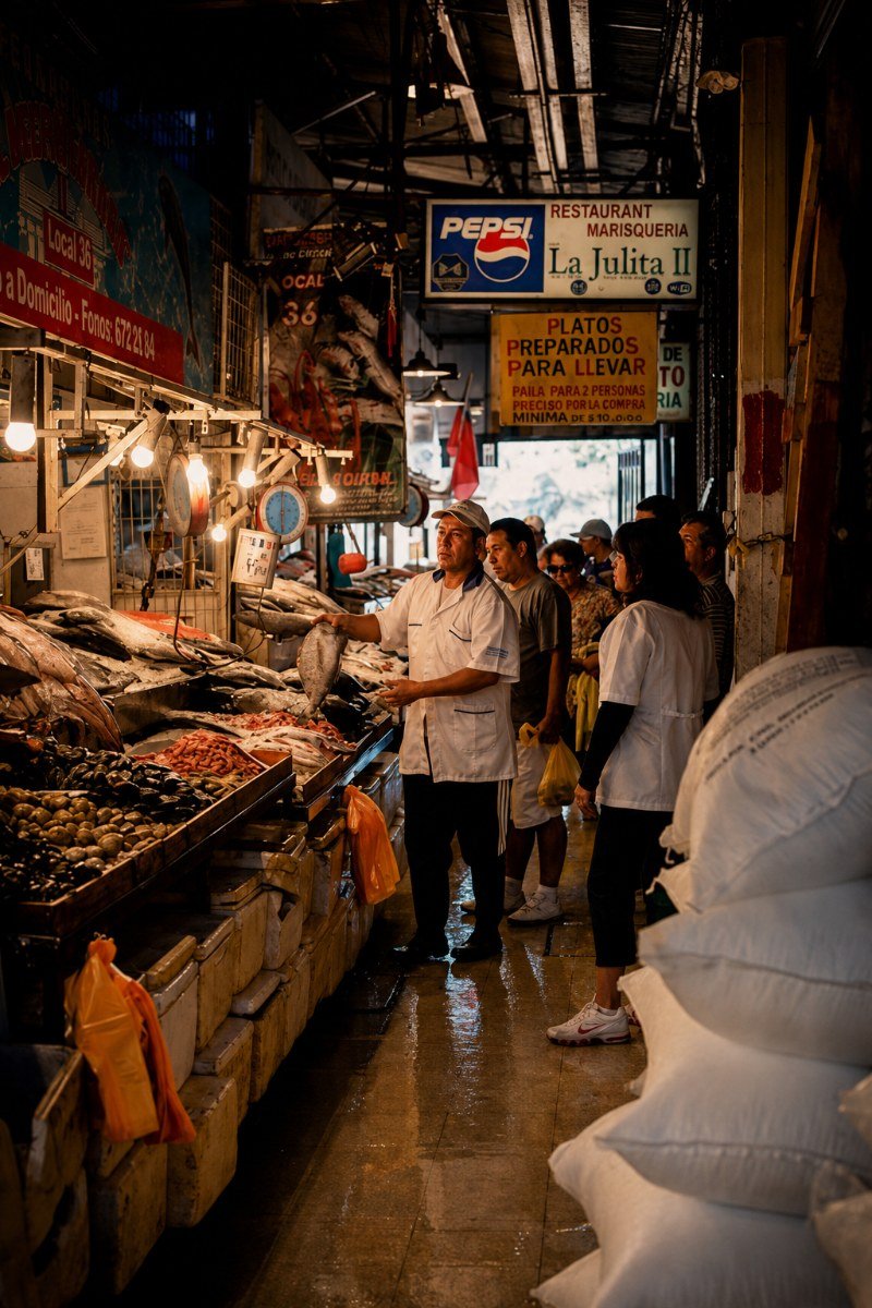 Chef del Mercado Central mostrando mariscos frescos a visitantes