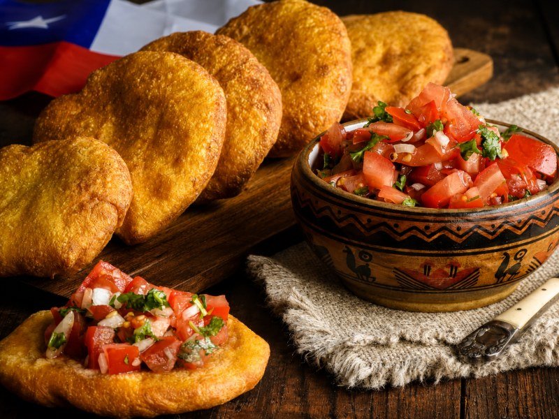Sopaipillas fritas con pebre y bandera chilena