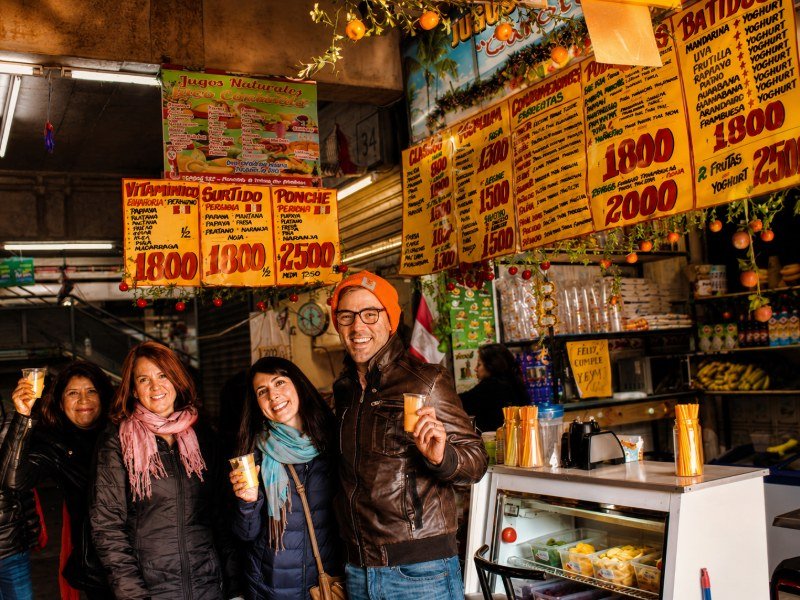 Grupo disfrutando jugos naturales en puesto del mercado Tirso de Molina